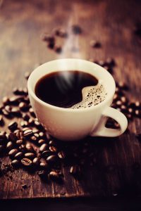 A cup of coffee with beans around it representing decaf coffee and prediabetes.