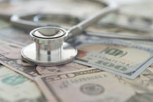 A stethoscope sits on top of $50 bills and $100 bills, showing the cost of Novolog can be an obstacle in the way of diabetics getting the insulin they need.