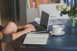 a woman types on a computer researching health insurance