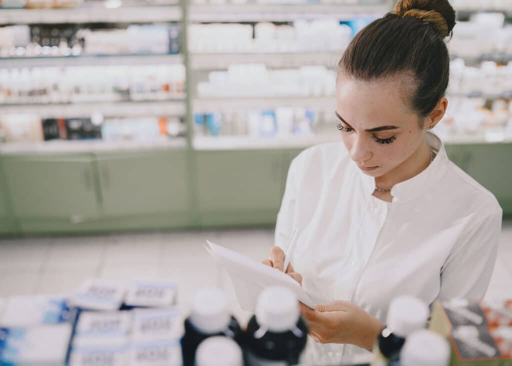 A pharmacist inventories shelves of medications like noxafil.