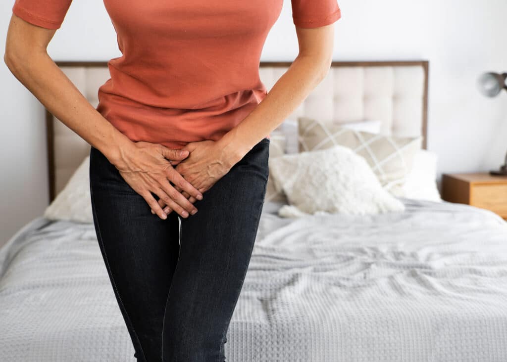 a woman holds her hands in front of her as though she has a urinary tract infection that could be solved by noroxin.
